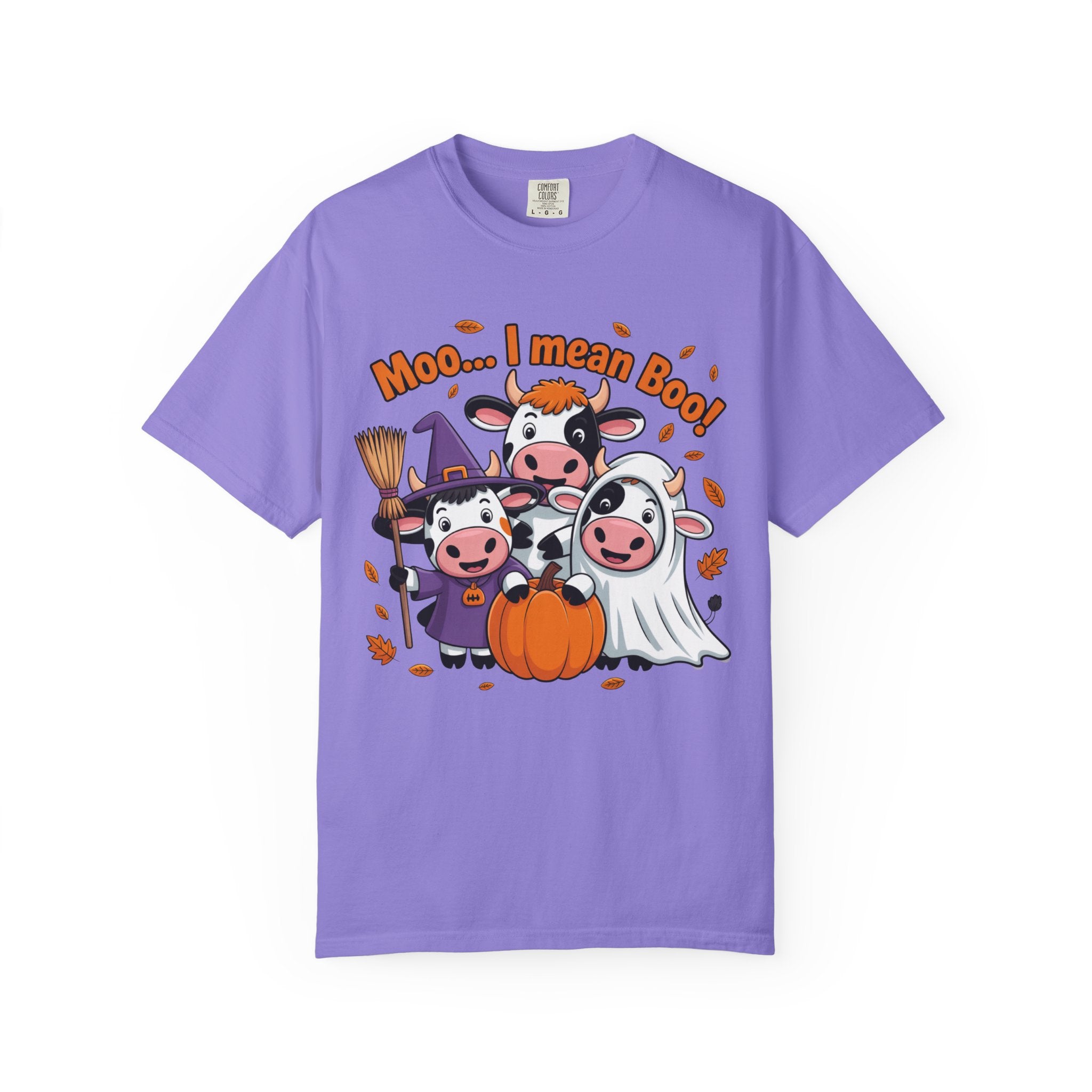 A purple short-sleeve crewneck t-shirt featuring a cartoon graphic of three cows in Halloween costumes (witch, cowboy, ghost) with a pumpkin, surrounded by orange text reading 'Moo.
