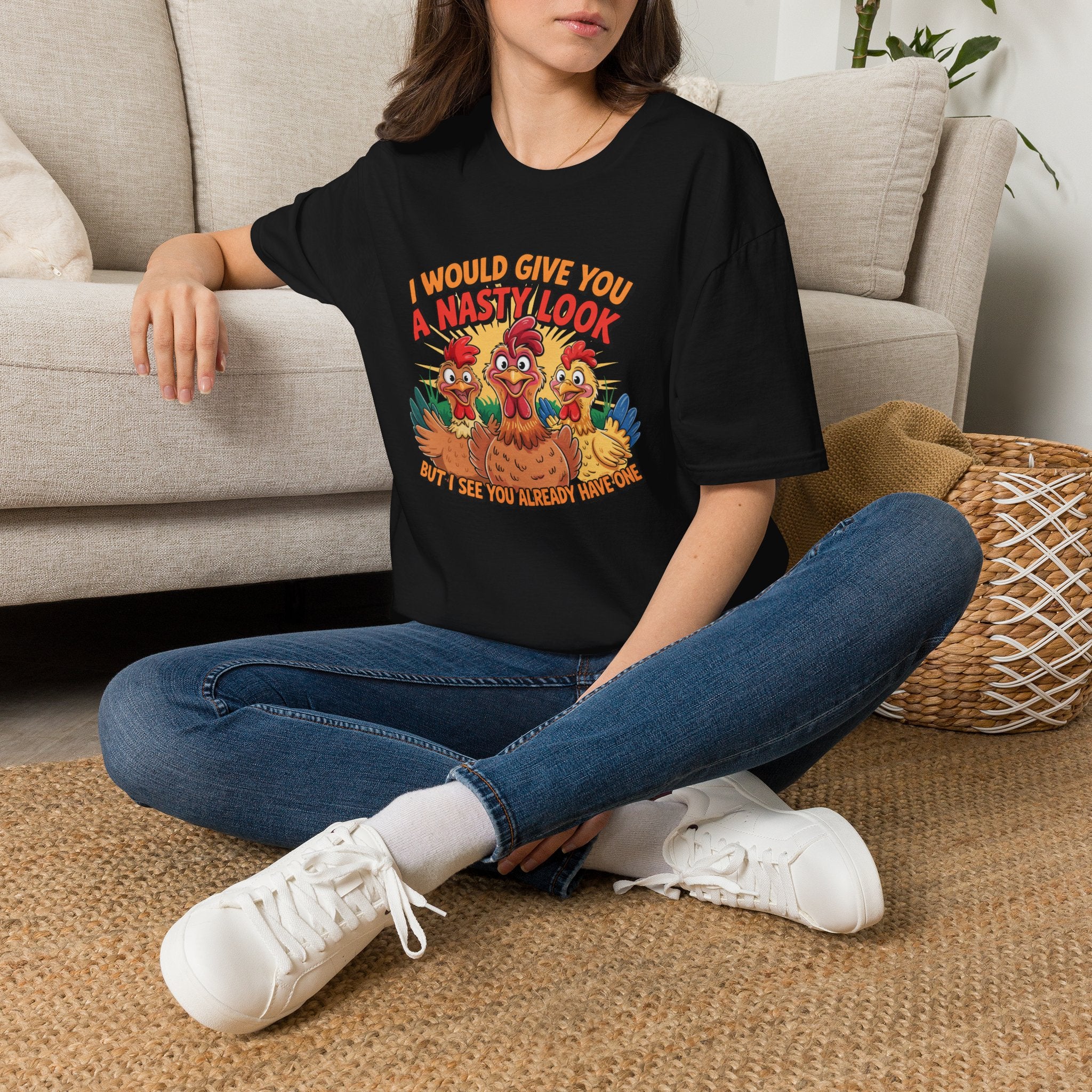 A woman sitting cross-legged on a woven rug in front of a beige sofa, wearing a black graphic T-shirt with a colorful turkey design and the text 'I WOULD GIVE YOU A NASTY LOOK' and 'DON'T SEE YOU ALREADY ANOTHERONE'.
