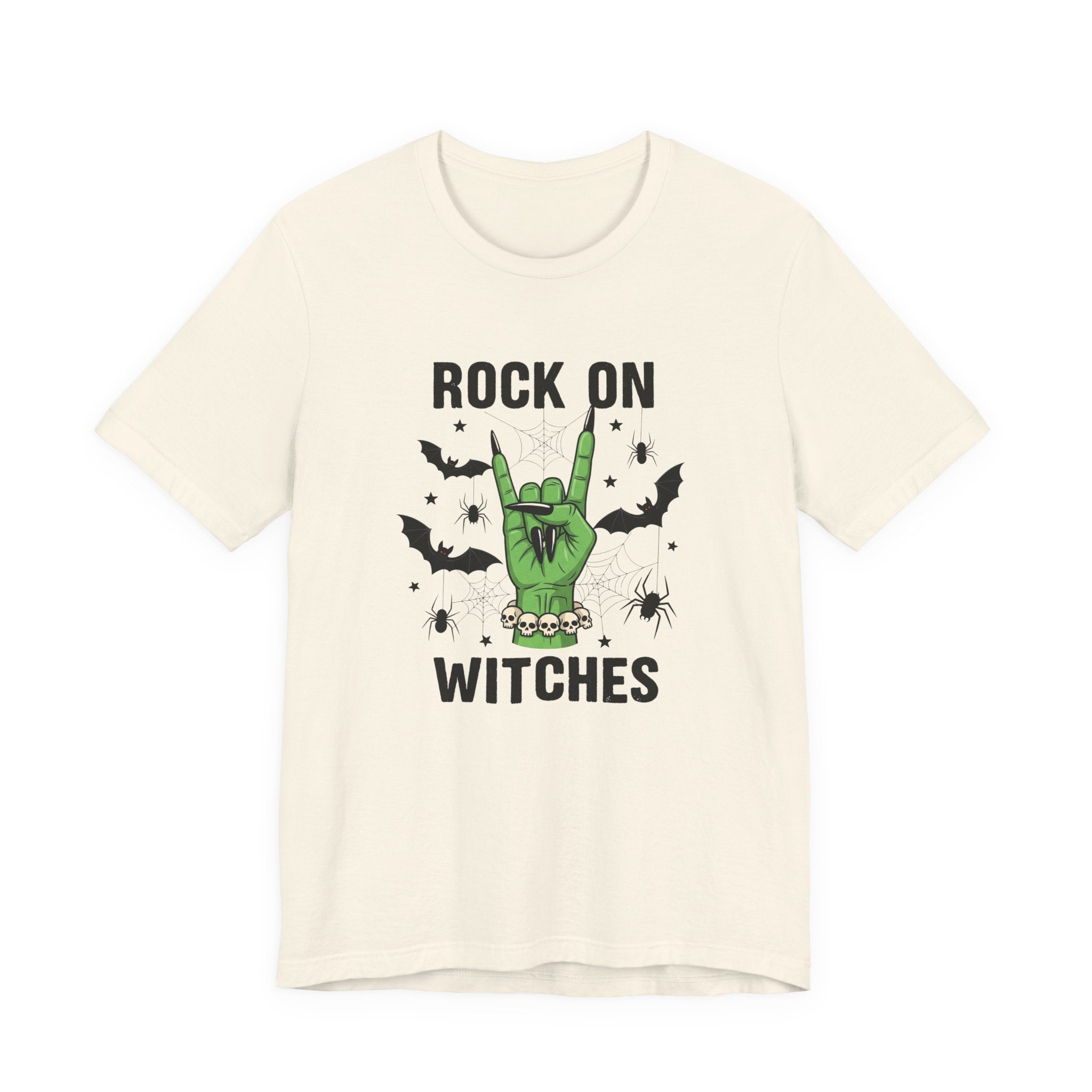 An off-white short-sleeve t-shirt with a graphic print on the front. The graphic features a green hand making the rock on gesture, surrounded by black bats, spiders, and cobwebs, with the text 'ROCK ON WITCHES' in black above and below the illustration.
