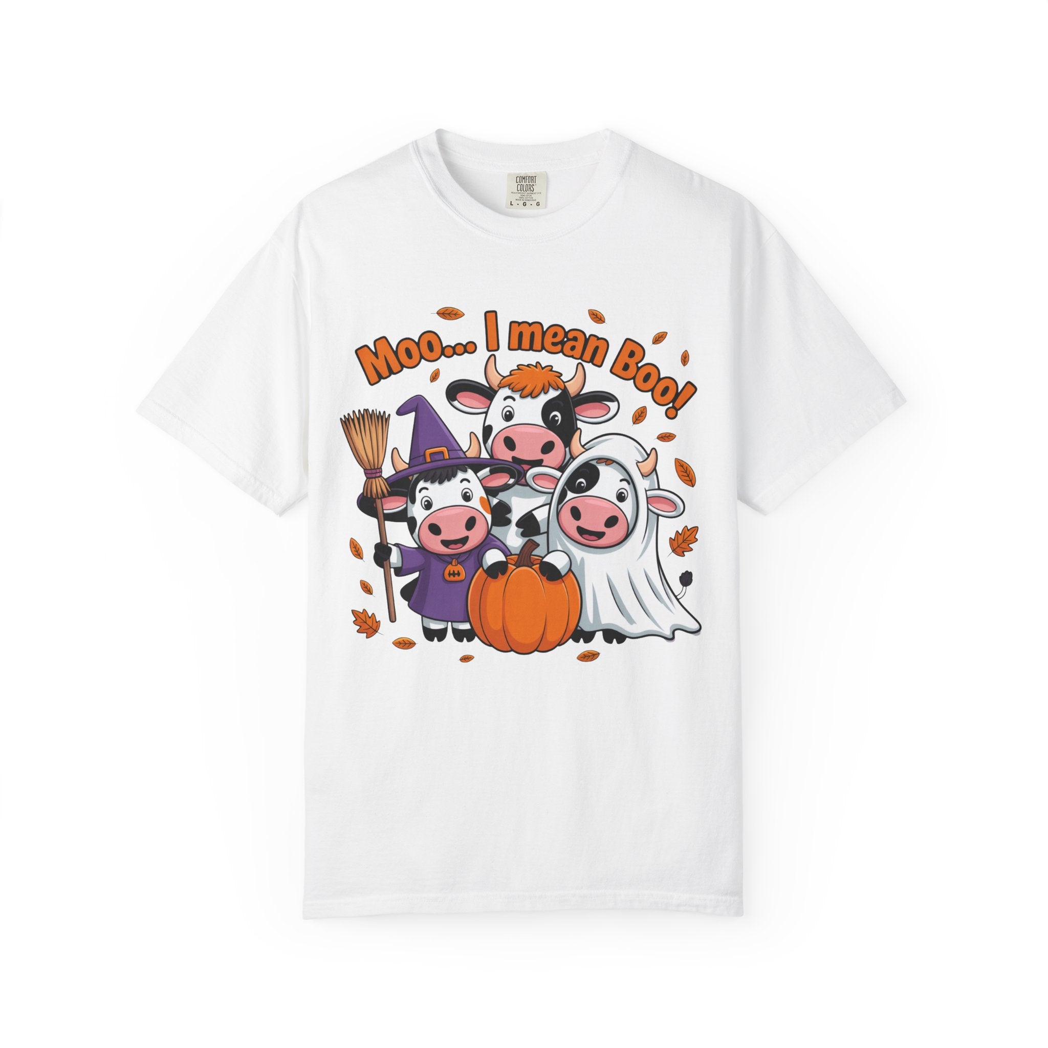 A white short-sleeve crewneck t-shirt featuring a colorful cartoon graphic of four cute cows in Halloween costumes (wizard, witch, cowboy, ghost) with an orange pumpkin and the text 'Moo.