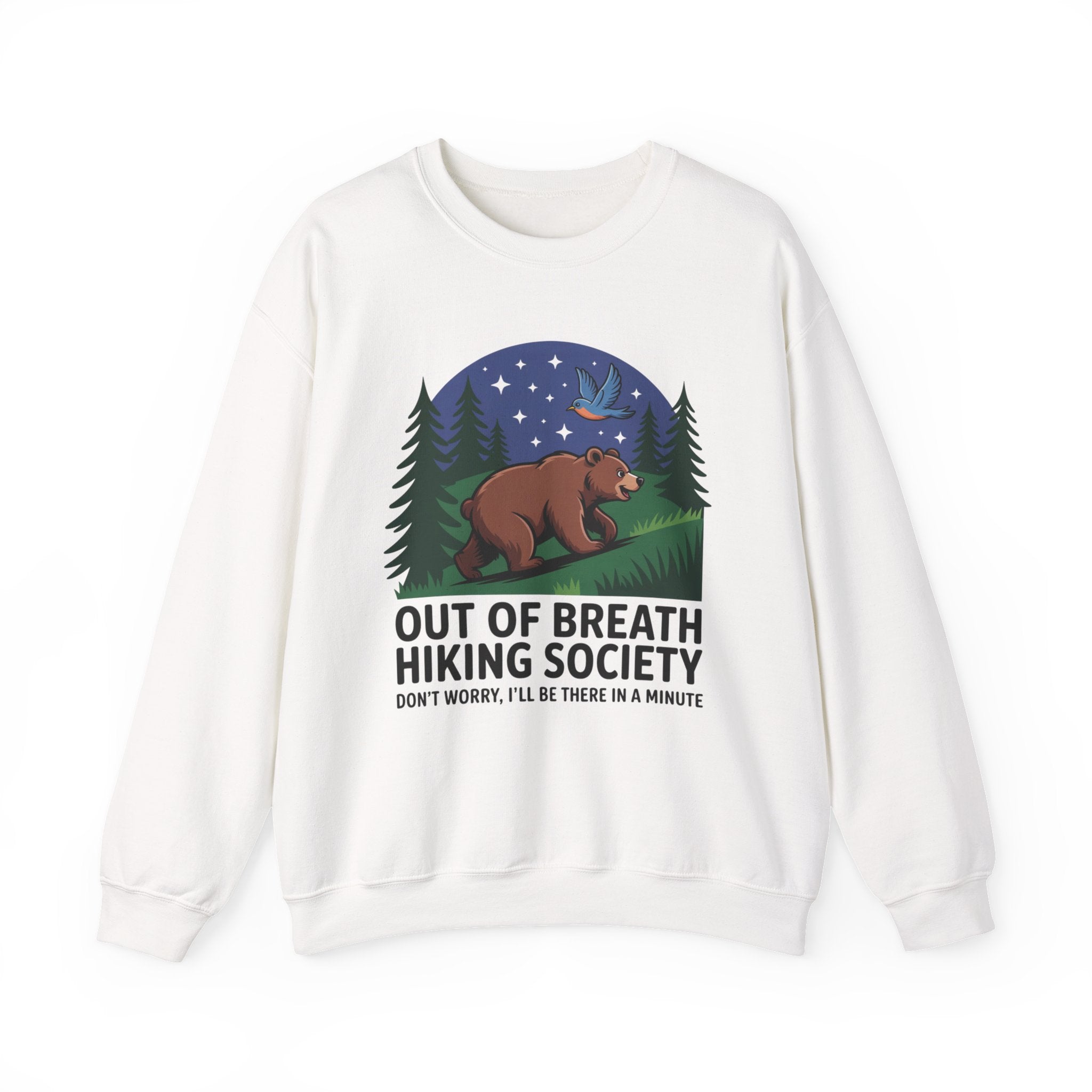 A white crewneck sweatshirt featuring a graphic print of a brown bear under a starry night sky with pine trees, accompanied by the text 'OUT OF BREATH HIKING SOCIETY' and 'DON'T WORRY, I'LL BE THERE IN A MINUTE'.