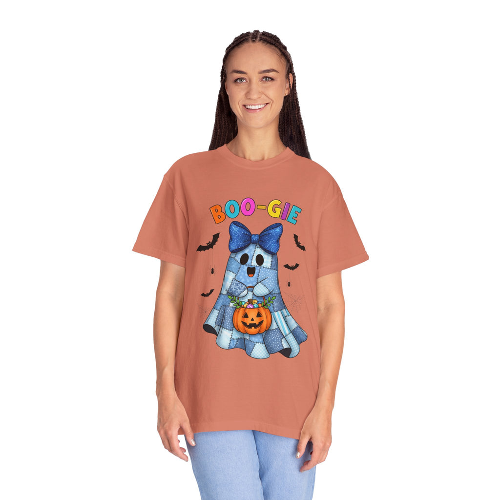 A woman modeling a terracotta-colored short-sleeve t-shirt with a colorful Halloween graphic of a ghost dog holding a jack-o'-lantern, with the text 'BOO-GIE' above it.