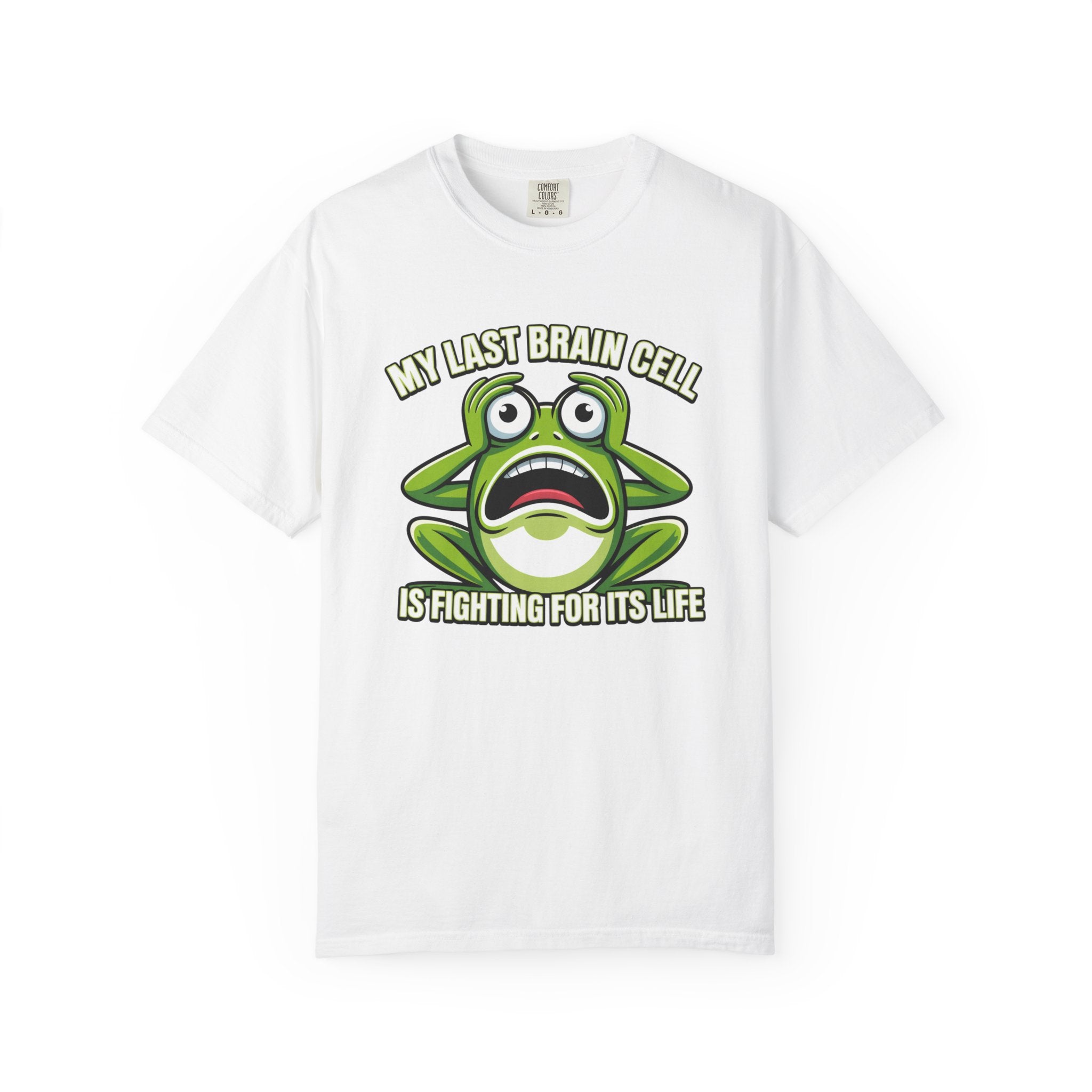 A white short-sleeve crewneck t-shirt featuring a cartoon graphic of a green frog with a shocked expression and the text 'MY LAST BRAIN CELL IS FIGHTING FOR ITS LIFE' printed on the front.