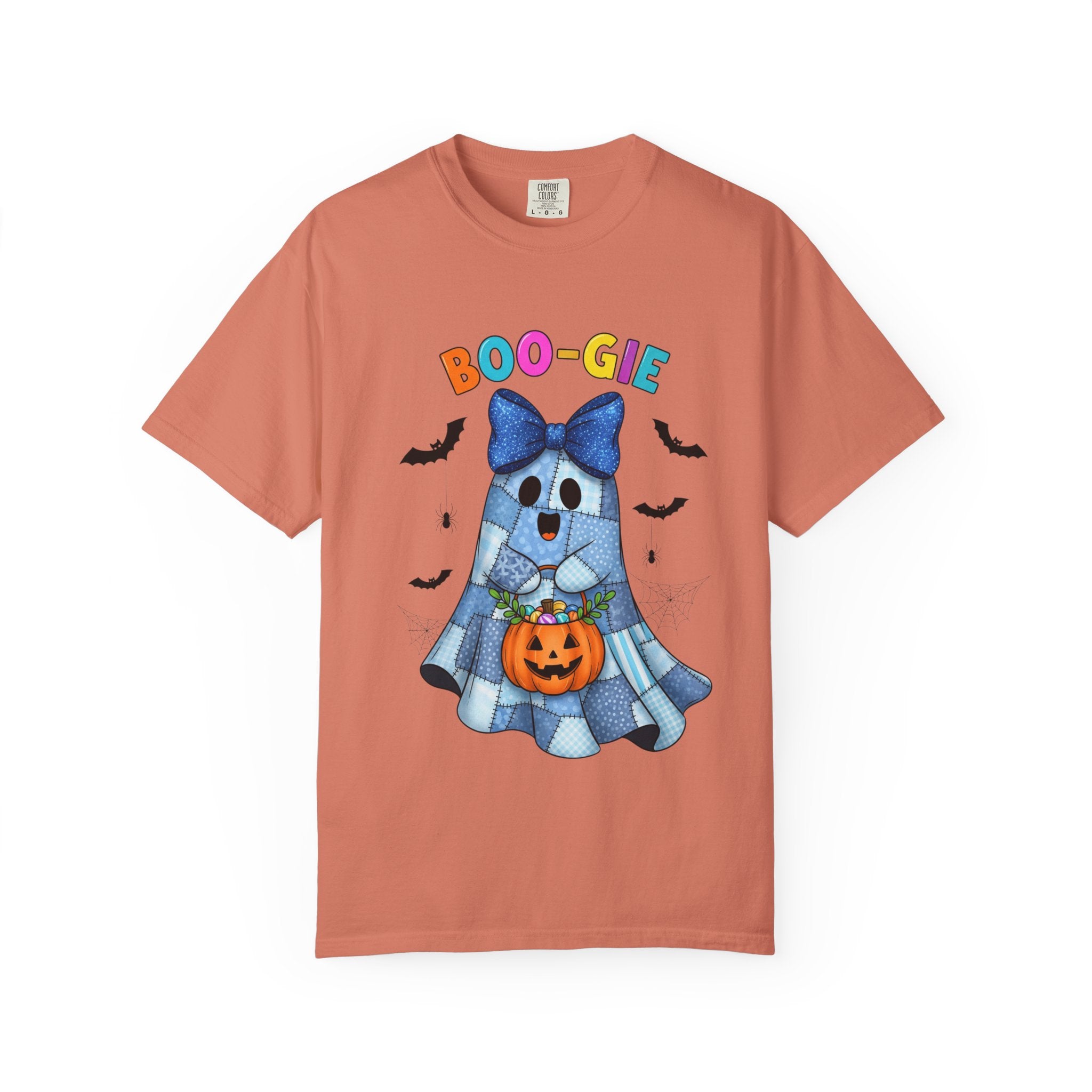 A peach-colored short-sleeve t-shirt with a Halloween graphic on the front. The graphic features a cute blue ghost character wearing a large blue bow and holding an orange jack-o'-lantern pumpkin, with the text 'BOO-GIE' written above in colorful letters.
