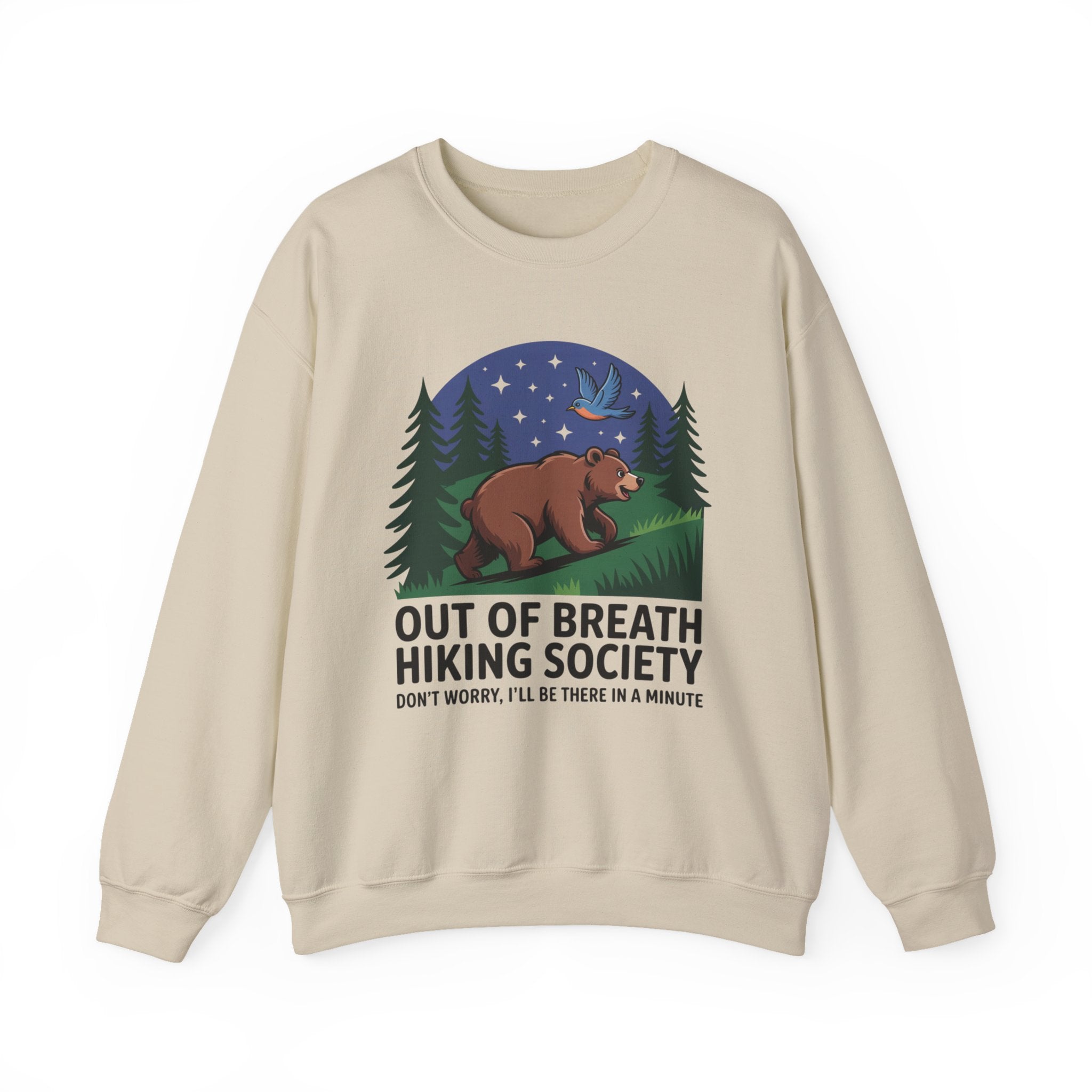 A beige crewneck sweatshirt featuring a graphic of a brown bear under a starry night sky with pine trees, and the text 'OUT OF BREATH HIKING SOCIETY' and 'DON'T WORRY, I'LL BE THERE IN A MINUTE'.