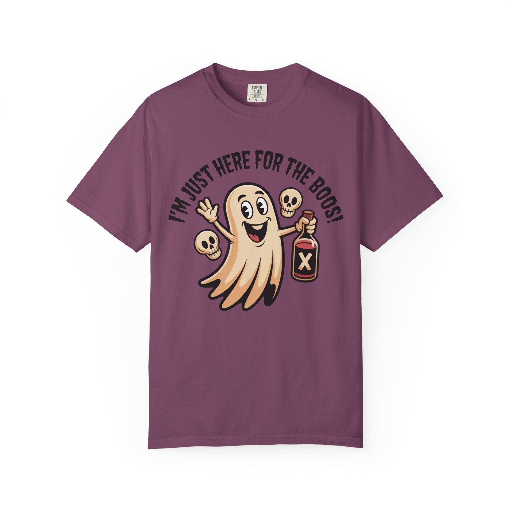 A purple short-sleeve crewneck t-shirt featuring a cartoon graphic of a smiling ghost holding a poison bottle, with two skulls and the text 'I'M JUST HERE FOR THE BOOS!' arched above it, displayed on a clean white background.