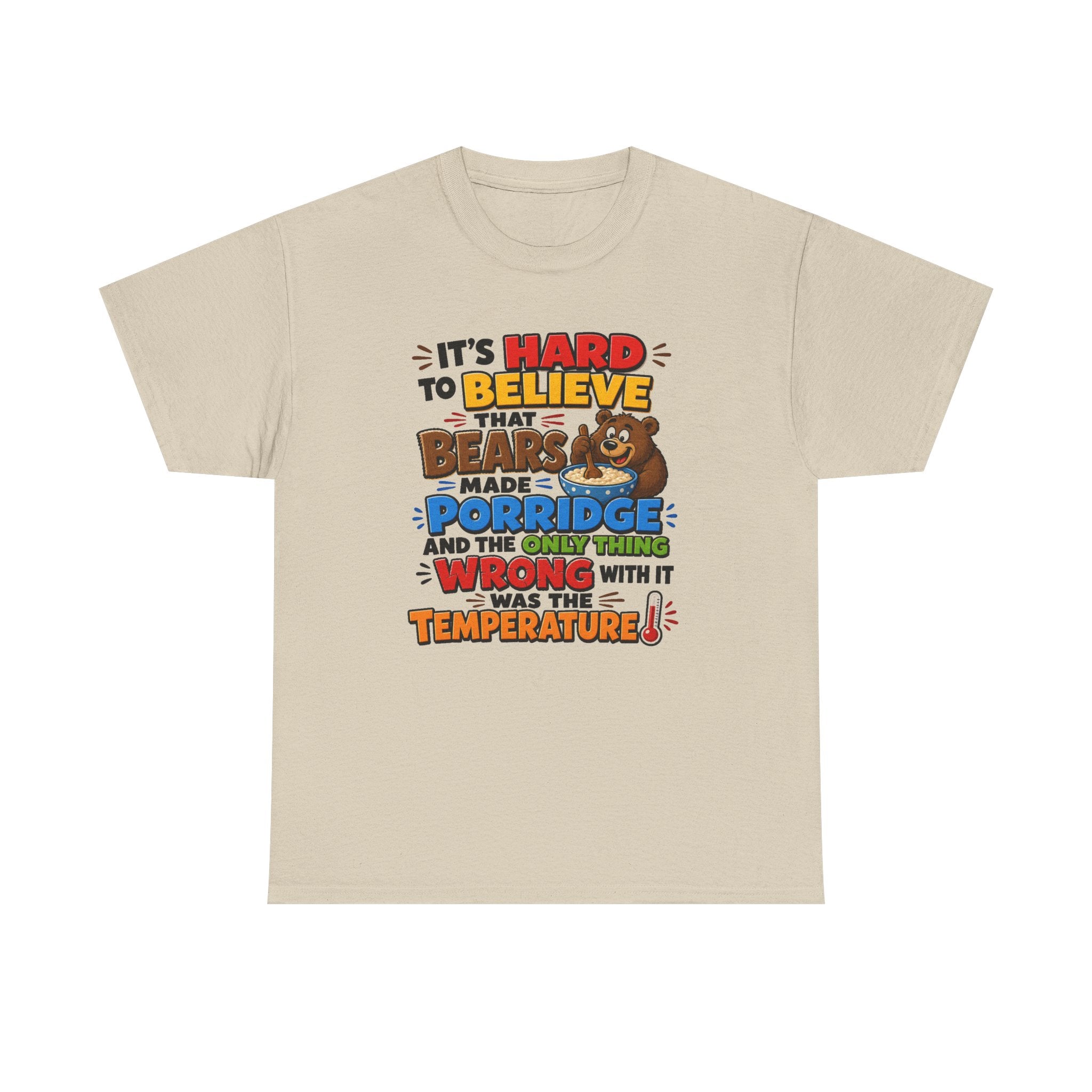A light beige crewneck t-shirt with a colorful graphic print on the front. The graphic features a brown cartoon bear and text that reads: 'IT'S HARD TO BELIEVE THAT BEARS MADE PORRIDGE AND THE ONLY THING WRONG WITH IT WAS THE TEMPERATURE!'.