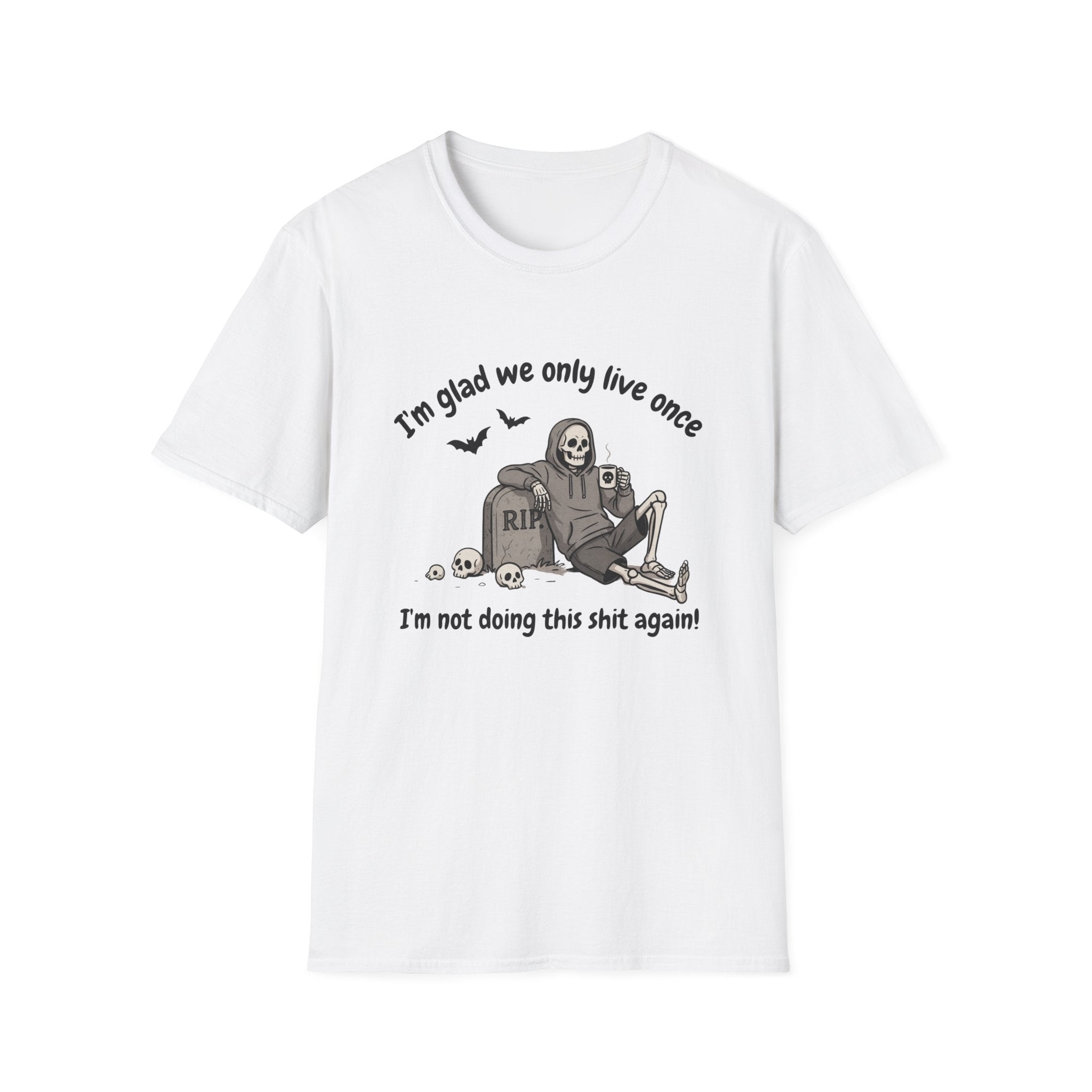 A white short-sleeve crewneck t-shirt featuring a humorous Halloween graphic of a skeleton sitting on a tombstone with the text 'I'm glad we only live once' above and 'I'm not doing this shit again!' below.