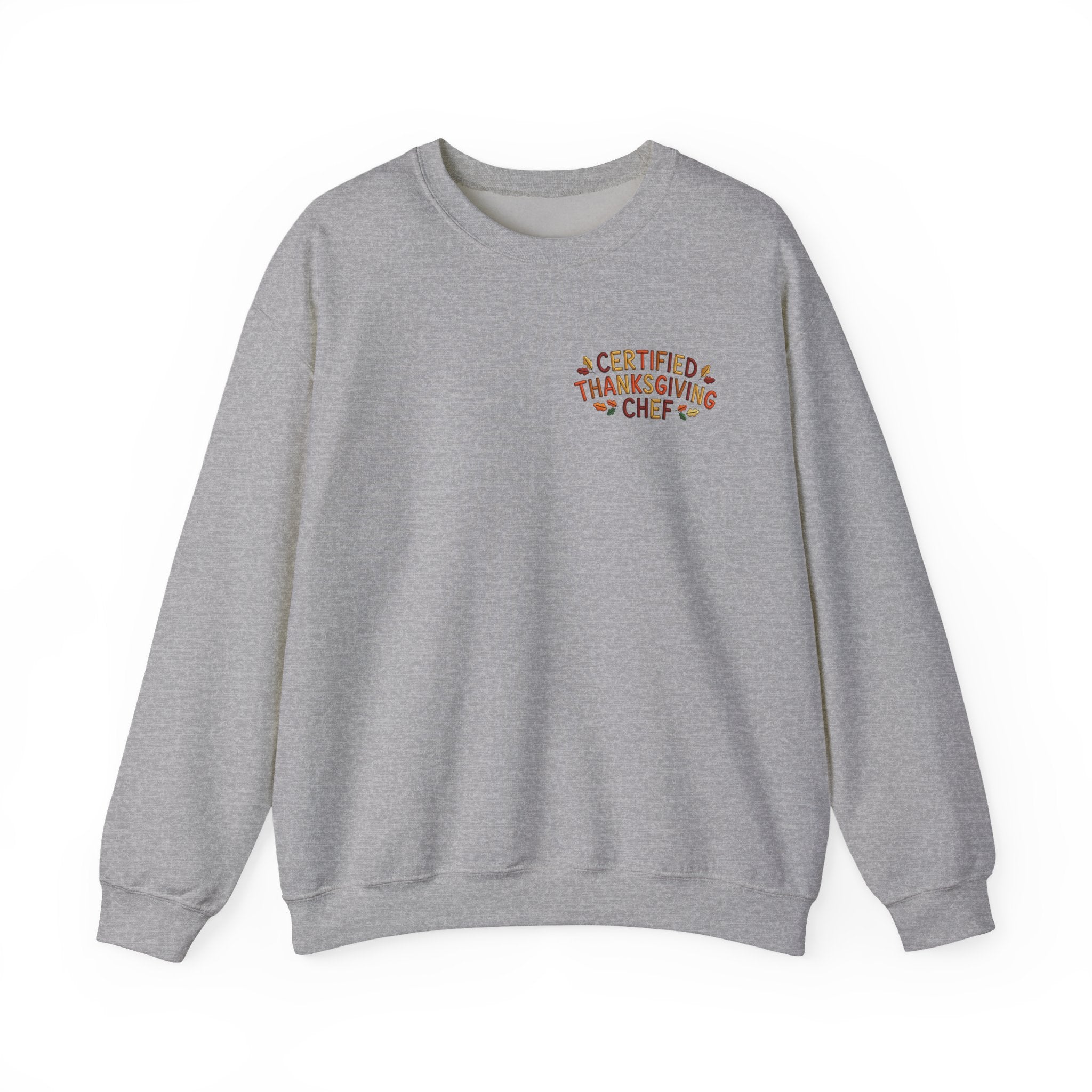 A heather gray crewneck sweatshirt with a small graphic on the left chest reading 'CERTIFIED THANKSGIVING CHEF' in orange and yellow lettering, displayed on a clean white background.