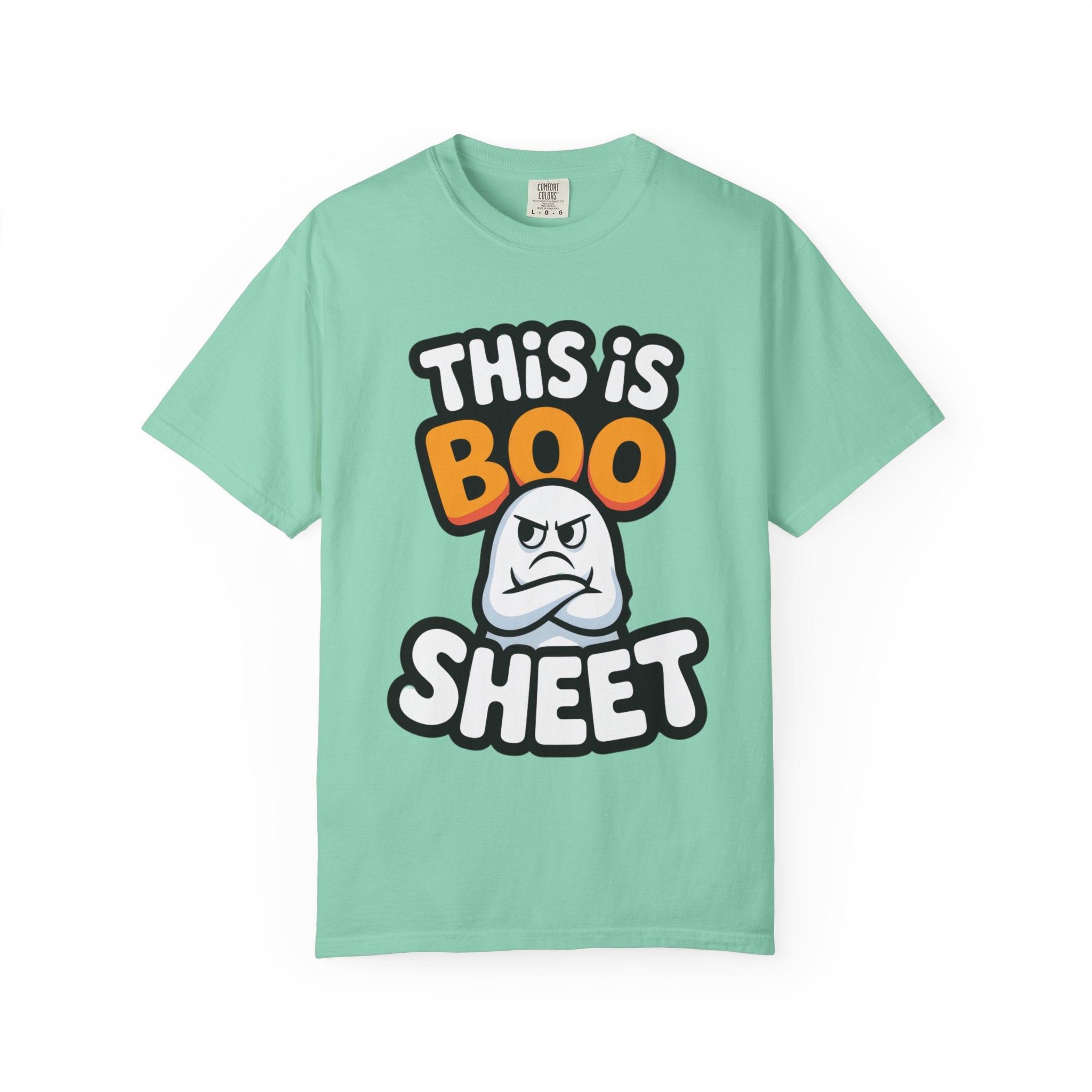 A mint green short-sleeve t-shirt with a graphic print that reads 'THIS IS BOO SHEET' in stylized white, orange, and black lettering, featuring a cartoon angry ghost in the center, displayed on a clean white background.