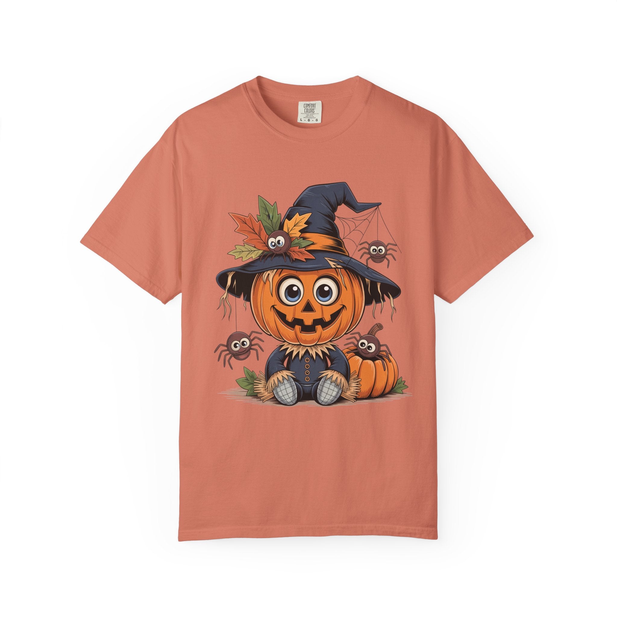 A peach-colored short-sleeve t-shirt featuring a cartoon graphic of a smiling jack-o'-lantern wearing a witch hat with autumn leaves, surrounded by small spiders and pumpkins, shown on a plain white background.