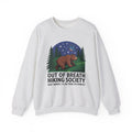A light heather gray crewneck sweatshirt featuring a graphic print of a brown bear under a starry night sky with pine trees, and the text 'OUT OF BREATH HIKING SOCIETY' and 'DON'T WORRY, I'LL BE THERE IN A MINUTE'.