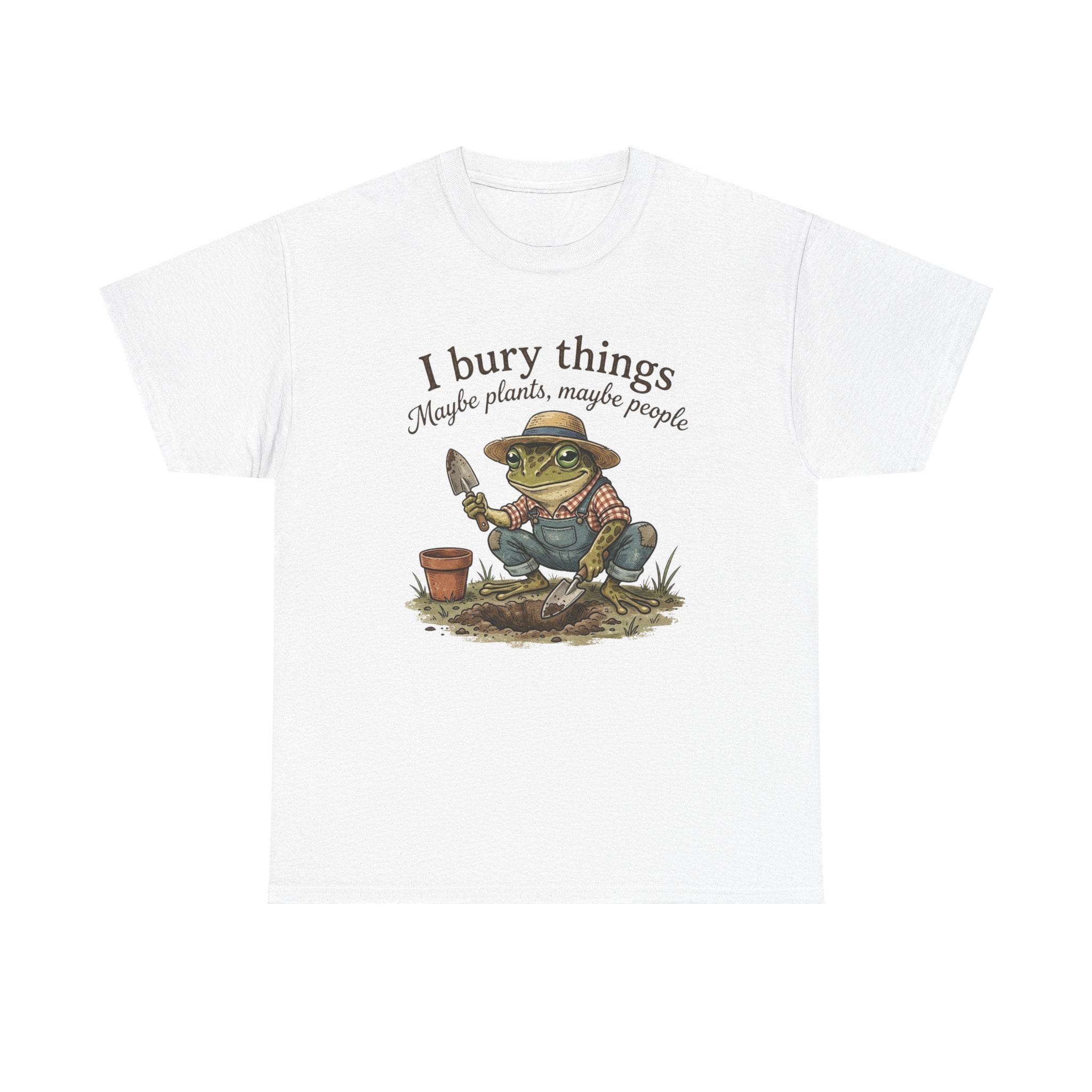 A white short-sleeve crewneck t-shirt featuring a cartoon graphic of a green frog wearing a straw hat and gardening overalls, holding a trowel. Above the graphic, the text reads 'I bury things Maybe plants, maybe people'.