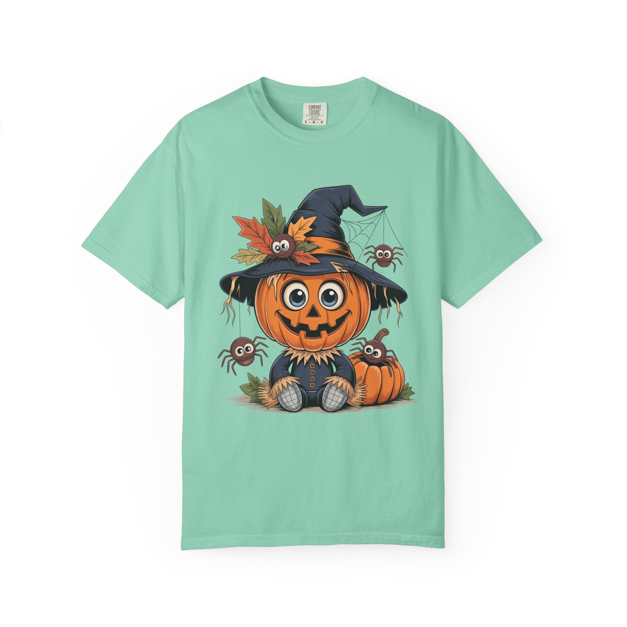 A mint green short-sleeve t-shirt with a colorful graphic of a cute cartoon pumpkin wearing a witch hat and surrounded by autumn leaves and spiders, displayed on a clean white background.