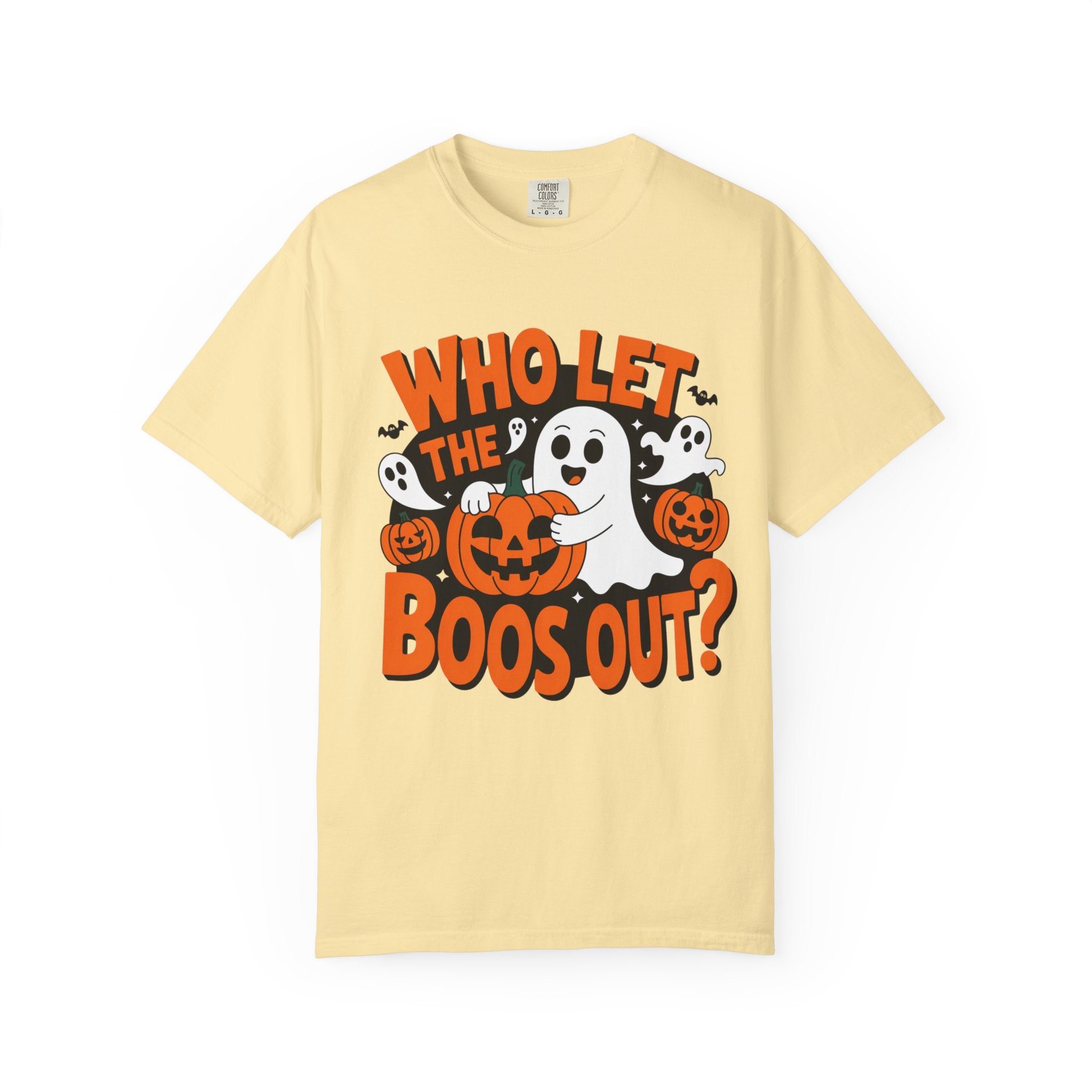 A pale yellow short-sleeve crewneck t-shirt featuring a Halloween graphic with the text 'WHO LET THE BOOS OUT?' in orange, white ghosts, and jack-o'-lanterns, shown on a plain white background.