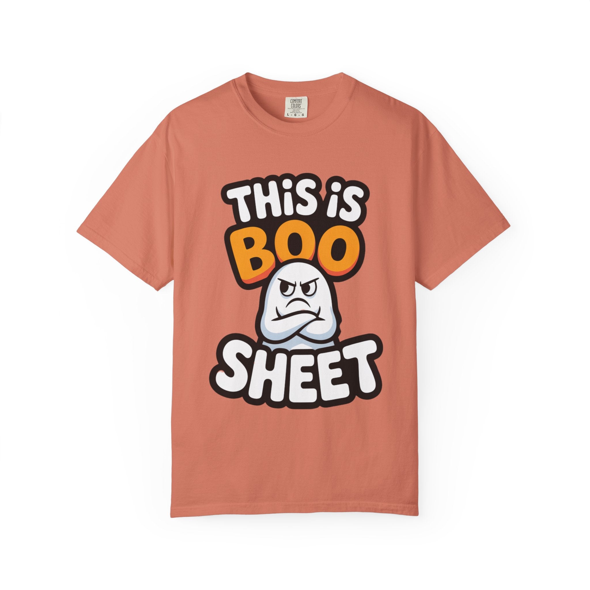 A peach-colored short-sleeve t-shirt with a graphic on the front that reads 'THIS IS BOO SHEET' in bold white and orange lettering, featuring a cartoon angry ghost in the center, displayed on a clean white background.